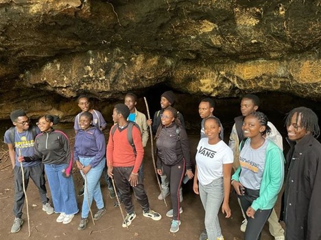 Group posing for a photo in a cave within the Karura Forest